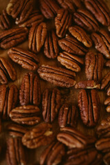 Pecan nuts close up view on wooden background with selective focus. 