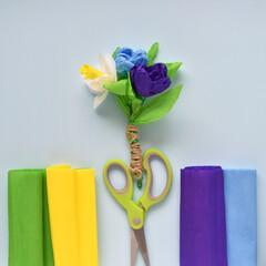 bouquet of spring flowers narcissus and crocuses made from corrugated paper on a blue background