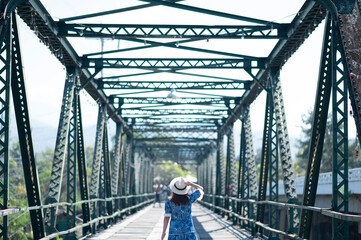 Woman traveller sightseeing on Pai Memorial bridge in Pai, Chiang Mai, Thailand.