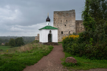 View of the Chapel of the Korsunskaya Icon of the Mother of God against the background of the Talavskaya Tower and the wall of the Izborsk fortress on a summer day, Izborsk, Pskov region