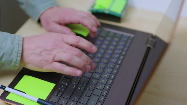 Close up view of hands of man typing on computer keyboard. Sweden.