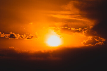 Fototapeta na wymiar 暑い雲に隠れる前の太陽と夕焼け空