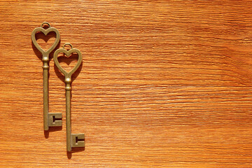 Two heart shaped retro keys on a wooden table