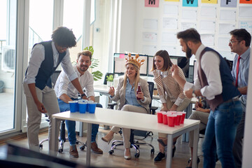 A group of cheerful employees is playing during a break at job in the office. Employees, job, office