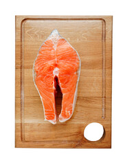 Raw fish salmon steak on wooden cut board on white background close up view