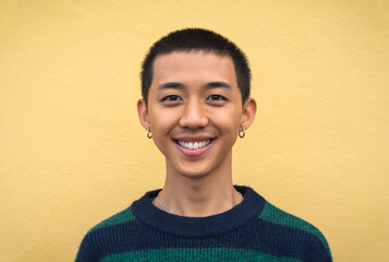 Portrait of happy young Asian teenager smiling in front of camera