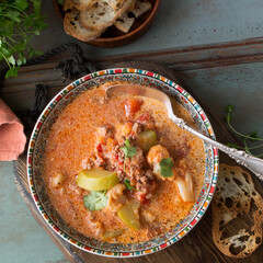 plate with tomato-creamy soup with minced meat on the table