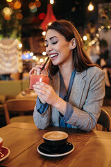 Beautiful young adult woman sitting in a nice restaurant or coffee bar and enjoying in fresh good coffee drink.