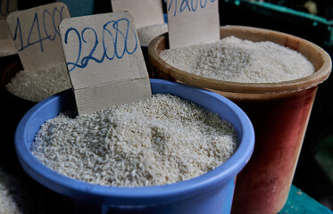 Dry white rice in buckets on Ban Co market, Ho Chi Minh City, Vietnam.             