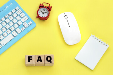 Wooden cubes with word FAQ .keyboard, mouse. Notepad.