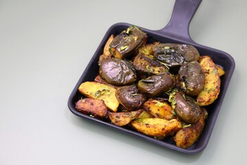 Baingan masala. Indian Potato and aubergine curry. Homemade Indian spicy eggplant and potato curry, served in a white plate. Copy space.