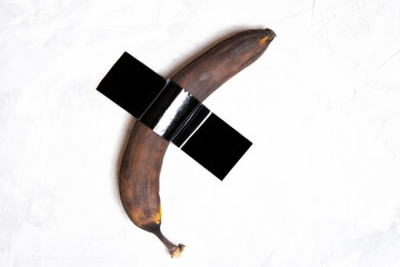 Brown banana duct-taped to a wall