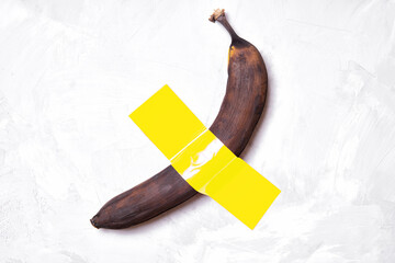 Ripe brown banana duct-taped to a wall