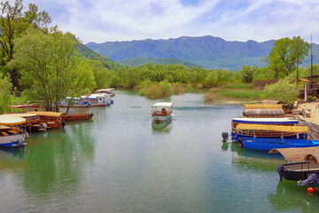  Montenegro. National Park Lake Skadar, Virpazar village. Beautiful mountain landscape with tourist boats on river