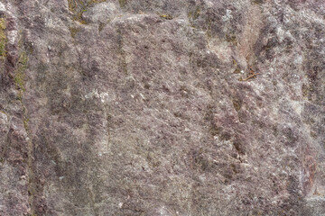 Rough rough surface of gray-pink stone with inclusions, for use as an abstract background and texture.