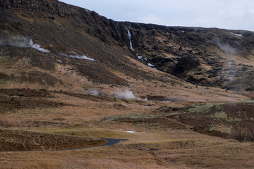 Fototapeta na wymiar Dampf von heißen Quellen im Tal Reykjadalur nahe dem Ort Hveragerði. / Steam from hot springs in the Reykjadalur valley near the village of Hveragerði.