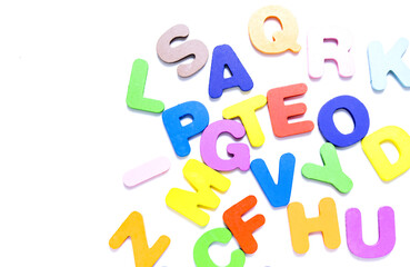 English alphabet made of square wooden tiles with the English alphabet scattered on white background.