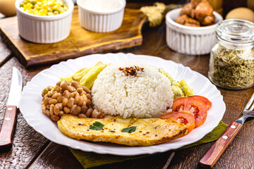 typical brazilian lunch rice and beans, grilled chicken fillet and fries, homemade food, rustic...