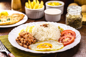 plate of rice and beans typical of brazil, healthy and light food, fried egg and salad, brazilian...