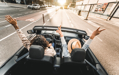 Happy couple driving on city street in convertible car - Friends rent cabrio auto on vacation -...