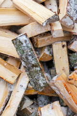 Chopped birch firewood lies in a heap on the snow in winter - 488167979