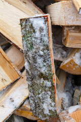 Chopped birch firewood lies in a heap on the snow in winter - 488167985