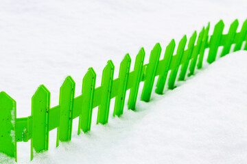 Green plastic fence in the snow in the garden in winter - 488168186