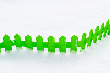 Green plastic fence in the snow in the garden in winter - 488169355