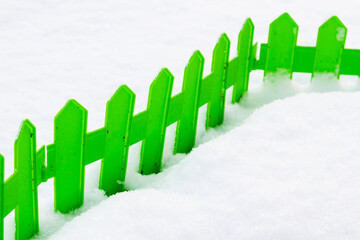 Green plastic fence in the snow in the garden in winter - 488169388