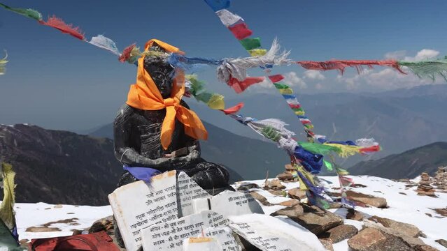 A small buddha statue with prayer flags on Gosaikunda trail in Langtang National Park, Himalayas, Nepal
