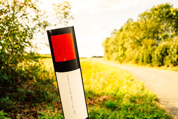 Close-up of a leaning plastic road bollard seen learning following a traffic accident. Located a a dangerous hairpin.