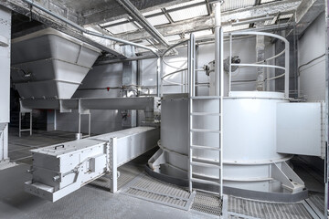 Industrial workshop interior white bunker auger conveyor and crusher
