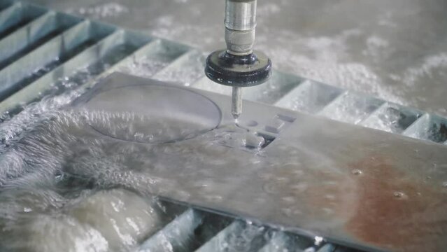 Waterjet metal cutting. Hydroabrasive high pressure CNC machine is cutting out a shape on a metal sheet