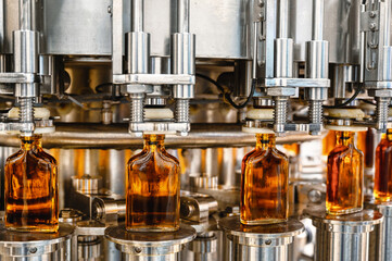 Automatic production line fills glass bottles with cognac - 488174348