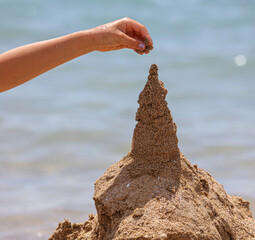 Man plays in the sand by the sea.