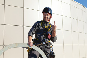 An industrial climber shows an indecent gesture to the camera