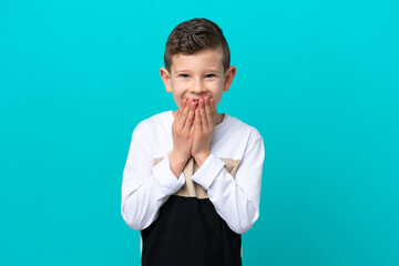 Little kid boy isolated on blue background happy and smiling covering mouth with hands