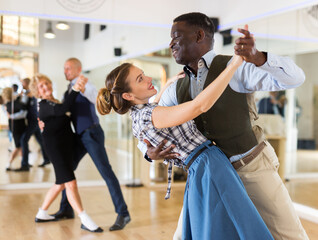 Woman with american man practising ballroom dancing