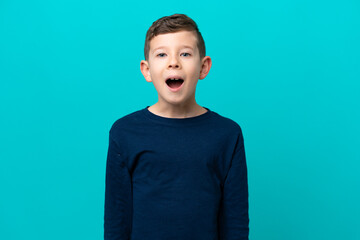 Little kid boy isolated on blue background with surprise facial expression