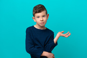 Little kid boy isolated on blue background having doubts