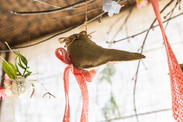 Hanging ribbon and bird shape linen fabric and flower clear glass vase on background , artificial flowers hang in a wedding party or interior. Decoration indoors