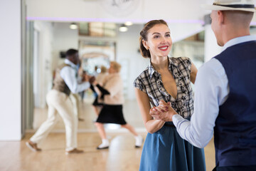Cheerful female practicing lindy hop in pair with man
