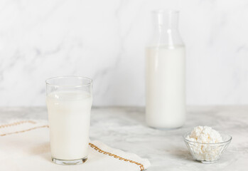 Homemade kefir, buttermilk or yogurt with probiotics. Yogurt with a glass bottle and glass on a light background. Probiotic cold fermented milk drink. Trendy food and drinks.