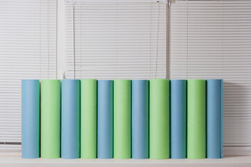 Naklejka premium Lots of yoga mats sit on the windowsill waiting for class.