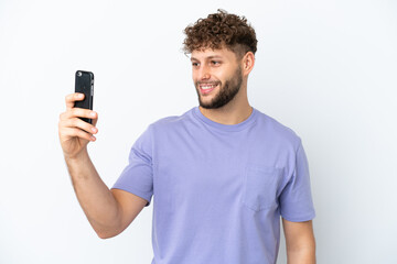 Young handsome caucasian man isolated on white background making a selfie