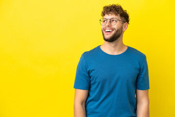 Fototapeta premium Young handsome caucasian man isolated on yellow background laughing