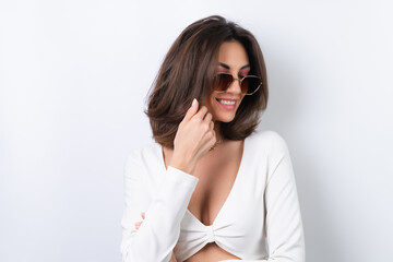 Young woman in a cocktail dress, gold chain, bright spring pink makeup on a white background. In fashionable stylish sunglasses.