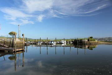 Blue sea and poles reflected on water at Knysna Boat Club