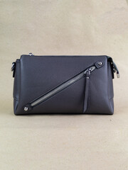 A beautiful women's bag stands on a paper background.