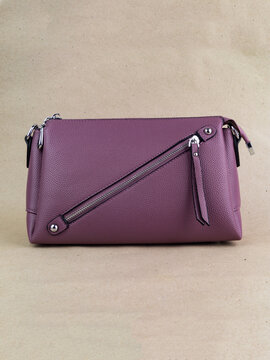 A beautiful women's bag stands on a paper background.